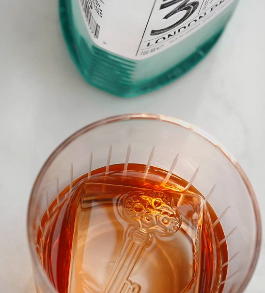 Cocktail glass with gin bottle next to it