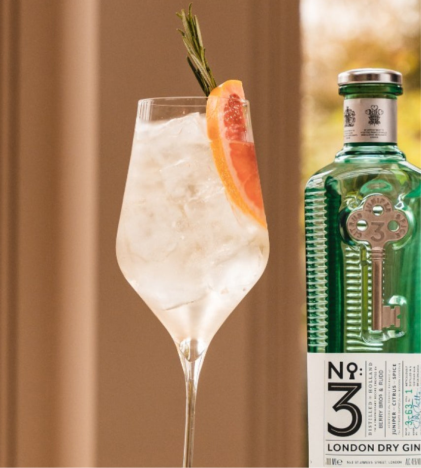 A summer cocktail with a bottle of No 3 Gin next to it